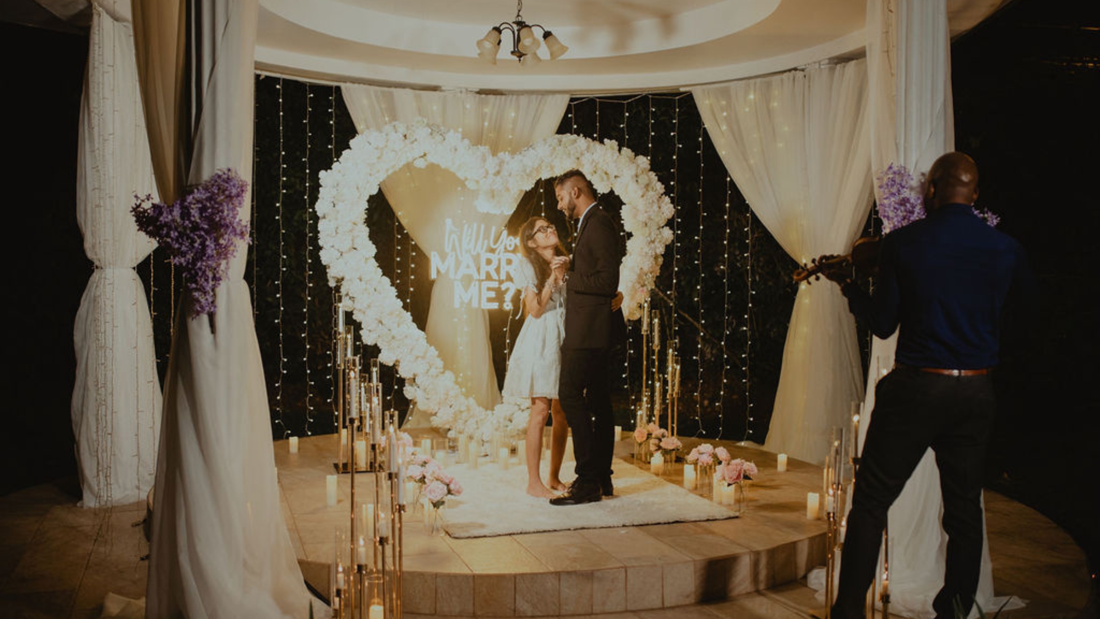 Couple dancing in front of White Heart arch proposal as Cardiac Strings plays their song for marriage proposal in Trinidad and Tobago.